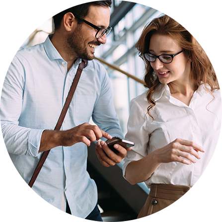 Two women in suits standing beside wall